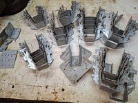 Top view of grouped joist hangers and flat connector plates on workbench