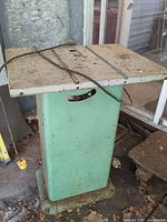 Full view of steel router table, green pedestal base and steel top