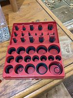 red organizer case open showing multiple sizes of black O-rings