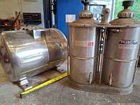 Wallmaster dual reservoir beside horizontal stainless tank with tape measure for scale