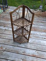 Plant stand assembled showing three shelves and arched back