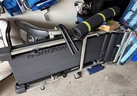 Disassembled Horizon T93 treadmill base, side rails, and console components