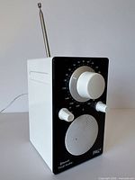 Front three-quarter view showing radio, knobs, speaker grille and antenna