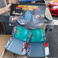 Front of bilingual Battleship box held above console
