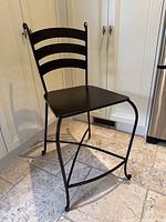 Full view of black wrought iron bar stool