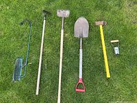 All six yard tools laid out on grass