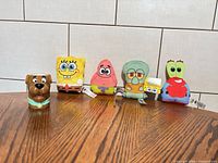 All four SpongeBob character plushes and Scooby-Doo mug lined on table