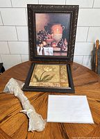 Group shot of both framed prints, wrapped blind and planner pad on table