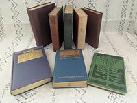 Group shot showing all eight cloth-bound books, three with covers visible