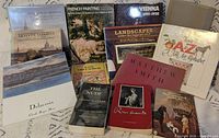 Front covers of all 12 art books displayed upright and flat