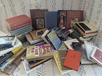 Overall lot showing mix of ~50 religion-themed books in a pile