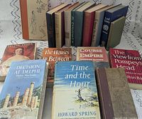 Front and rear rows of standing books with six laid flat, showing variety and condition