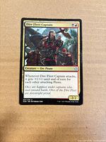Front of Dire Fleet Captain card showing artwork, text, set symbol and card number
