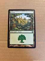 Front of Forest basic land card showing artwork, set symbol, collector number