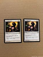 Two Avenging Arrow cards side by side on cardboard background