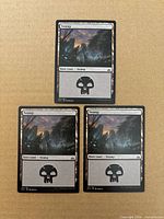 Three Swamp full-art cards laid out on surface