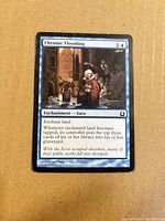 Front of Chronic Flooding card showing title, mana cost, artwork and text