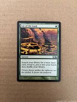 Front of Lay of the Land card showing artwork, set symbol M14, green border