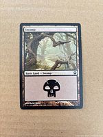 Front of 2013 Swamp basic land card showing artwork, title, and mana symbol