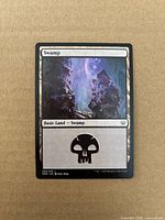 Front of Swamp card showing artwork, set code and collector number