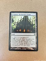 Front of Svogthos, the Restless Tomb card showing artwork, text, artist credit, and light edge wear
