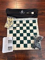 Entire set laid out: board, bagged pieces, carry case, rule sheet