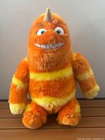 Front view of George Sanderson plush showing colors, horn, grin