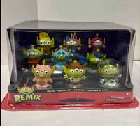 Front view of sealed Remix deluxe figurine set showing 10 aliens in costumes within clear packaging