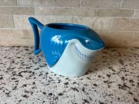 Side view of Bruce shark ceramic mug showing molded shape, color and handle