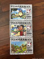 Three boxed puzzles stacked showing front artwork and Japanese branding