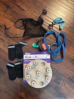 All items arranged: puzzle toy, box, leash, booties, waste-bag dispenser with roll, muzzle kit