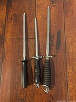 Three honing steels laid side by side showing overall design and wear