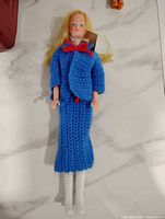 Full view of Barbie doll in blue crochet jacket and skirt with white boots