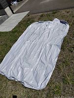 Full view of deflated gray air mattress laid flat outdoors