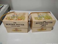 Front view of both boxed sets showing titles and rope handles
