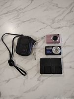Full lot showing two cameras, two chargers, case, wrist strap