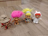 Group shot of four troll dolls on floor