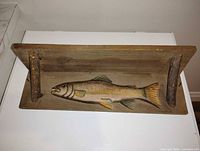Full view of wooden wall shelf showing fish carving and brackets