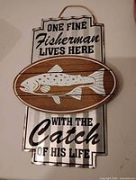Front view of fishing sign showing text, wood fish accent, and overall condition