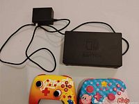 Overall lot showing dock, AC adapter, Pikachu and Kirby controllers