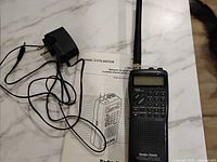 Scanner, AC adapter and manual laid out on table