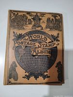 Front cover of tan hardcover “The World Postage Stamp Album”