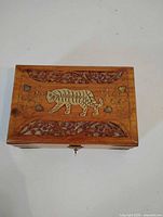 Top view showing brass tiger inlay and carved floral border