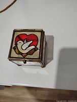 Top view showing stained-glass dove and heart motif lid
