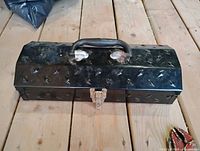 Closed black metal toolbox showing exterior condition