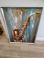 Front view of framed saxophone painting on tin