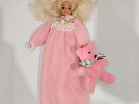 Full view of Bedtime Barbie doll in nightgown holding pink plush bear