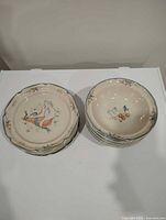 Stack of seven bowls beside stack of seven plates, overall view