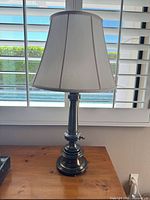 Entire lamp showing base, stem, and shade on table