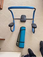 Ab roller frame and rolled exercise mat on carpet
